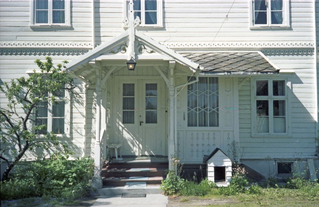 Pale blue clapboard house with a front porch and garden